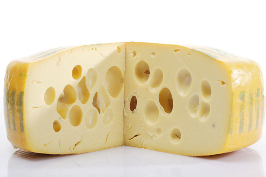 EMMENTAL TRADITIONAL SWISS STYLE CHEESE WITH HOLES.